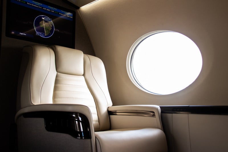 a luxury seat on a private jet getting hit with light from the window