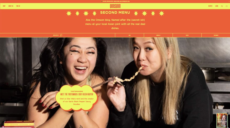 Omsom's fun red and yellow website featuring a big photo of two women in black- one laughing and one eating a noodle, with a caption mentioning meeting a chef.
