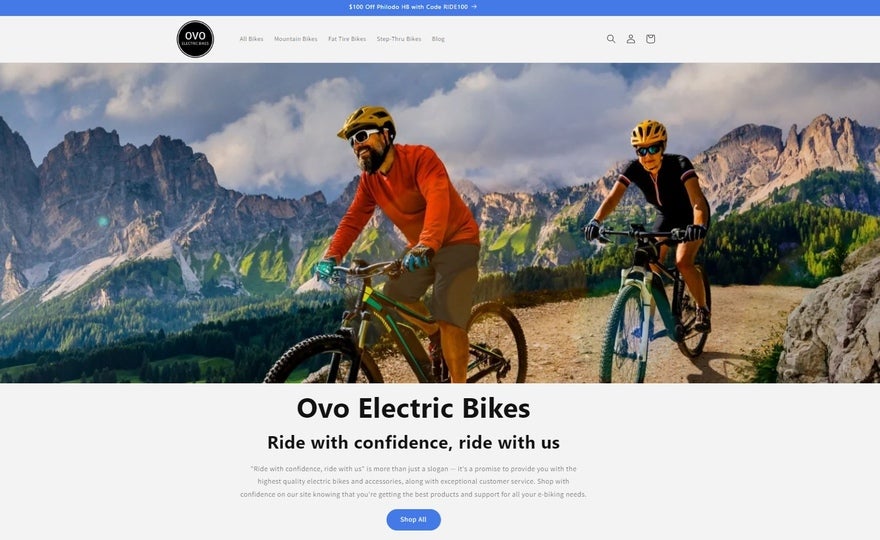 The Ovo homepage, showing two men riding electric bikes on a mountain pass with black text underneath.